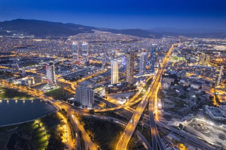 Téléchargez les photos : Ville d'Izmir dans la soirée. Izmir horbour et de nouveaux gratte-ciel dans le centre-ville d'Izmir, Turkiye. Longue exposition des lumières de la ville et de l'autoroute. - en image libre de droit