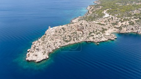 Foto aérea de avión no tripulado del hermoso y pintoresco cabo Melagavi formando una pequeña península con faro único se destacan junto al sitio arqueológico de Heraion, Loutraki, Grecia