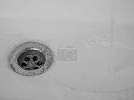 L'eau coule dans un évier en céramique blanche