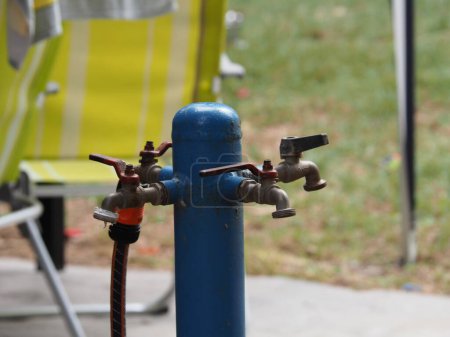 Blue hydrant for watering on a green lawn