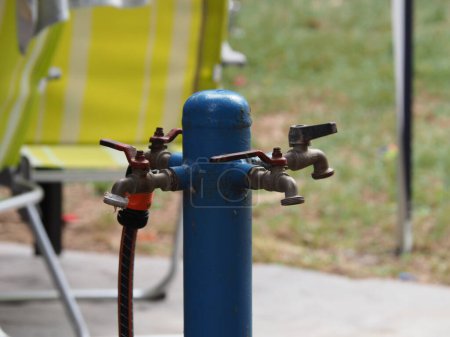 Blue hydrant for watering on a green lawn