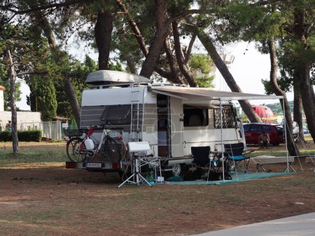 Téléchargez les photos : Camping dans une pinède avec camping-cars et tentes - en image libre de droit