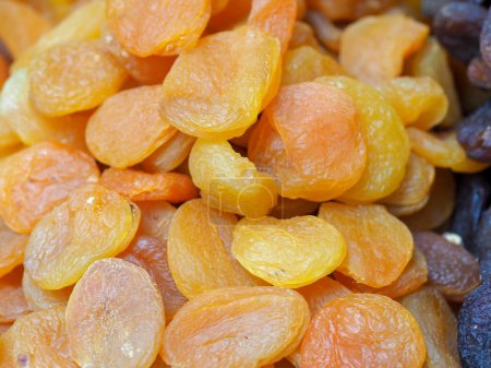 Téléchargez les photos : Abricots secs juteux sur fond de marché oriental : nuances de soleil et santé - en image libre de droit
