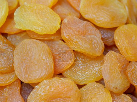 Téléchargez les photos : Abricots secs juteux sur fond de marché oriental : nuances de soleil et santé - en image libre de droit