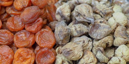 Téléchargez les photos : Eastern Delights : Abricots secs et Figues sur un comptoir de marché, une symphonie de saveurs et de senteurs - en image libre de droit