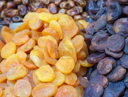 Téléchargez les photos : Comptoir de marché avec délices orientaux secs : abricots et pêches séchées dans une variété de couleurs - en image libre de droit