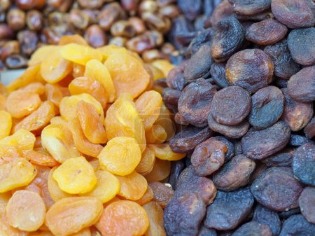 Téléchargez les photos : Comptoir de marché avec délices orientaux secs : abricots et pêches séchées dans une variété de couleurs - en image libre de droit
