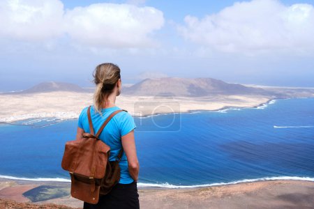 Foto de Vista trasera de una mujer madura admirando la isla de La Graciosa en Lanzarote. Islas Canarias - Imagen libre de derechos