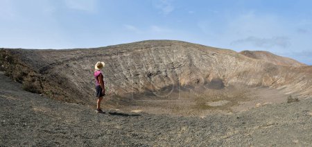 Foto de Mujer excursionista admirando el cráter del volcán caldera blanca en Lanzarote, Islas Canarias. - Imagen libre de derechos
