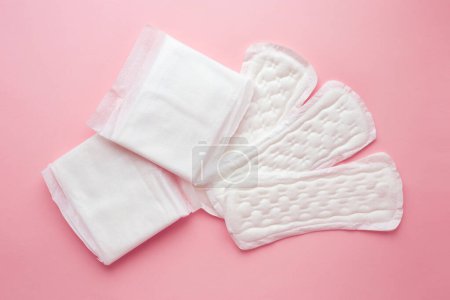 Different types of female pads during the menstrual cycle on a pink background. Feminine hygiene products during menstruation