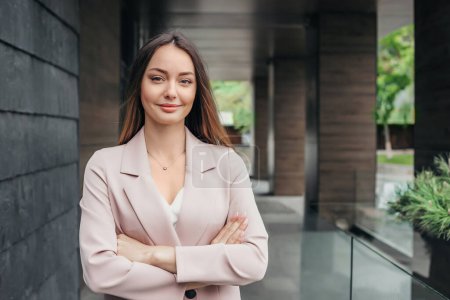Porträt einer erfolgreichen Geschäftsfrau mit gefalteten Händen vor dem Hintergrund eines Bürogebäudes. Unternehmensberaterin Analystin. Kopierraum