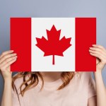 female hands holds blank white speech bubble with canadian flag isolated on blue background. Invitation to study in Canada concept