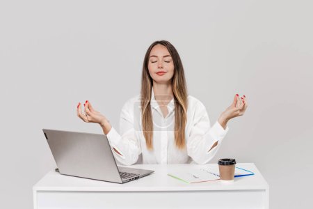 Photo for Caucasian young business woman meditate at work desk with closed eyes. girl take a break relax in office doing yoga at workplace feel balance no stress and peace of mind concept - Royalty Free Image