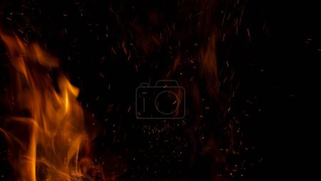Sparks and fire on a black background. Abstract blurred bonfire with sparks and flames