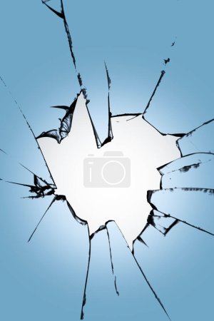 Foto de Trozos de vidrio roto con un agujero en el centro sobre un fondo azul. Textura de grietas en la ventana. Efecto de destrucción para el diseño - Imagen libre de derechos