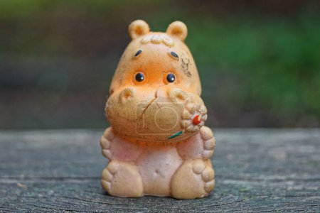 Foto de Un viejo juguete de plástico sucio viejo hipopótamo rosa se para en una mesa gris - Imagen libre de derechos
