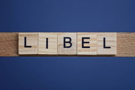 Photo for Text the word libel from brown wooden small letters on a black table - Royalty Free Image