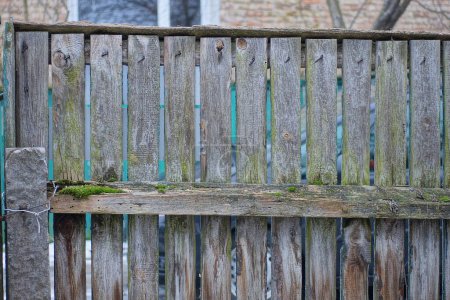 Foto de Part of a gray rural fence wall from wooden boards on the street - Imagen libre de derechos