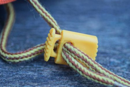 Photo for Two long brown yellow shoelaces with a plastic clip lie on a gray table - Royalty Free Image