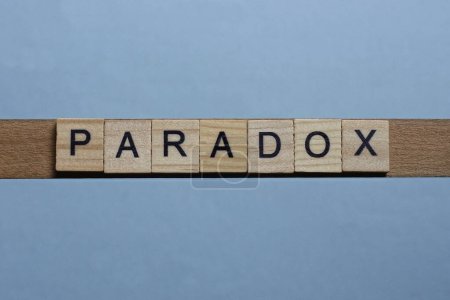 Photo for Text the word paradox from brown wooden small letters with black font on an gray table - Royalty Free Image