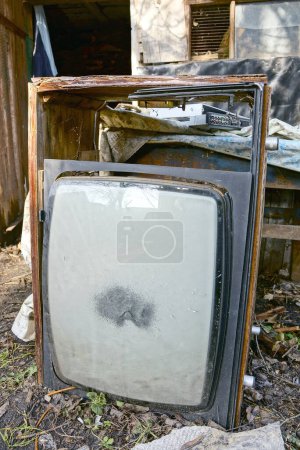 Téléchargez les photos : Ordures d'un vieux téléviseur cassé avec un tube gris debout sur le sol dans la rue - en image libre de droit