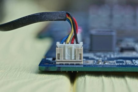 Téléchargez les photos : Un ensemble de fils électriques dans une prise sur un microcircuit d'un dispositif électronique sur une table jaune - en image libre de droit