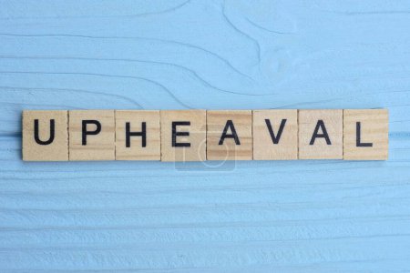 Photo for Word upheaval made from wooden gray letters lies on a blue background - Royalty Free Image