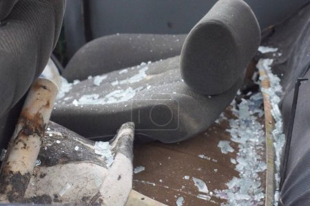 une chaise grise dans un morceau de verre blanc cassé dans une voiture après un accident