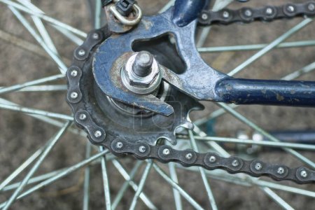 part of a bicycle wheel with gray spokes, a hub and a brake on a blue bicycle frame lies on the ground on the street