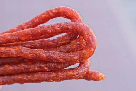 red thin dry hunting sausages on a gray background