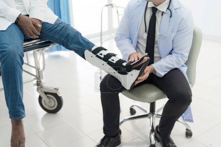 The doctor puts a splint on a patient with a leg injury.