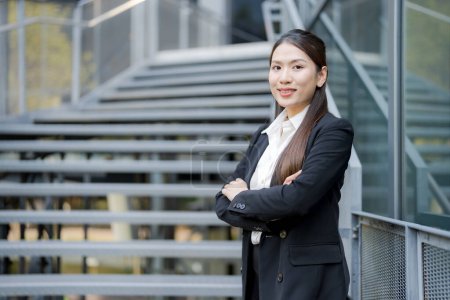 Mujer profesional en un traje sonriente, posado con confianza fuera de un moderno edificio de oficinas