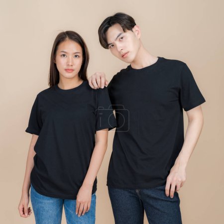 Junges Paar posiert selbstbewusst vor neutralem Hintergrund, trägt lässige schwarze T-Shirts, die sich perfekt für Branding oder Mode-Attrappen eignen und einen modernen und dezenten Stil präsentieren