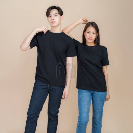 Junges Paar posiert selbstbewusst vor neutralem Hintergrund, trägt lässige schwarze T-Shirts, die sich perfekt für Branding oder Mode-Attrappen eignen und einen modernen und dezenten Stil präsentieren