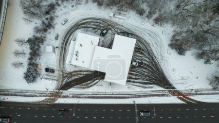 Drohnenaufnahmen direkt über der Tankstelle und Reifenabdrücke bei bewölktem Wintertag
