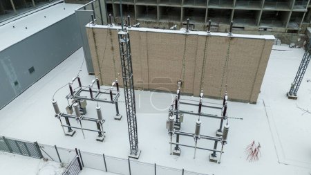 Drone photography of electrical sub station covered by snow during winter cloudy day