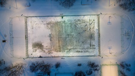 Drohnenfotos von Fußballfeldern, die mit Schnee bedeckt sind und Menschen, die im Winter Fußball spielen