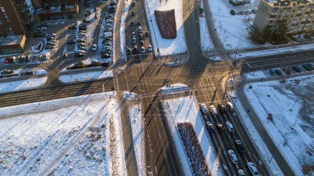 Photographie par drone de l'intersection de la route et de la ville couverte de neige pendant la matinée ensoleillée d'hiver