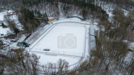 Drohne fotografiert Sportplatz an sonnigen Wintertagen mit Schnee