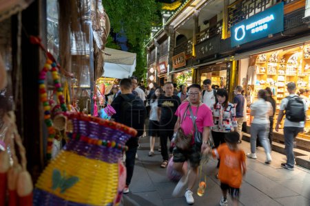 Foto de Chengdu, Sichuan, China, 04 de junio de 2023: Gente en la antigua calle Jinli, escena nocturna; Jinli Ancient Street es una conocida calle comercial peatonal en Chengdu - Imagen libre de derechos