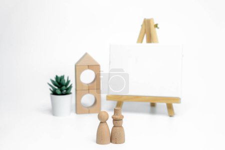 Photo for Wooden doll with empty easel on white background; business or creative concept - Royalty Free Image