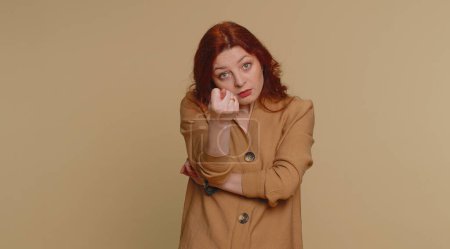Photo for Angry aggressive redhead woman showing fig negative gesture, you dont get it anyway. Rapacious, avaricious, acquisitive. Body language. Refusal fig sign. Greedy avaricious girl on beige background - Royalty Free Image