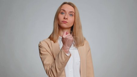 Photo for Greedy aggressive businesswoman showing fig negative gesture, you dont get it anyway. Rapacious, avaricious, acquisitive. Body language. Refusal fig sign. Female girl in suit. Woman on gray background - Royalty Free Image