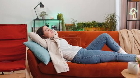 Photo for Portrait of tired young woman enjoy relaxing on home sofa in room. Happy pretty girl lying on couch resting napping after hard working day, closed her eyes, put hands behind head, stress free, rest - Royalty Free Image