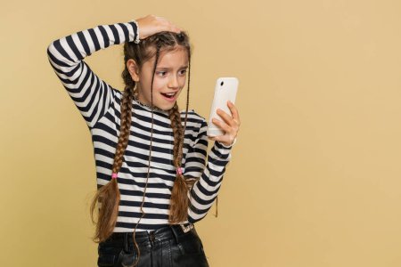 Upset sad preteen child girl kid use smartphone typing browsing, play game, loses, surprised by sudden lottery results, bad fortune, loss, fail, unlucky news. Sad children on beige background indoors