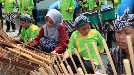 Foto de Grupo de artistas tradicionales que tocan música angklung y bailan alegremente, Pekalongan, Indonesia, 25 de agosto, 2022 - Imagen libre de derechos