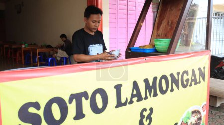 Photo for A soto lamongan seller prepares a menu at his stall Batang Indonesia, January 8 2023 - Royalty Free Image