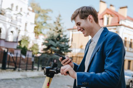 Téléchargez les photos : Jeune homme en costume utilisant smartphone pour scooter électrique louer. Concentration sélective. - en image libre de droit
