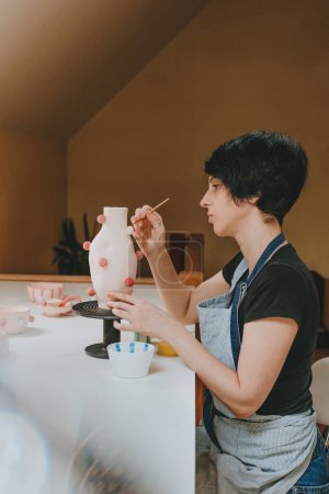Foto de Una joven ceramista trabajando en un taller de carros haciendo un jarrón. Enfoque selectivo. - Imagen libre de derechos