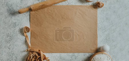 Photo for Paper with copy space near handmade pasta, rolling pin, flour and eggs. Top view, flat lay. Horizontal panoramic banner. - Royalty Free Image